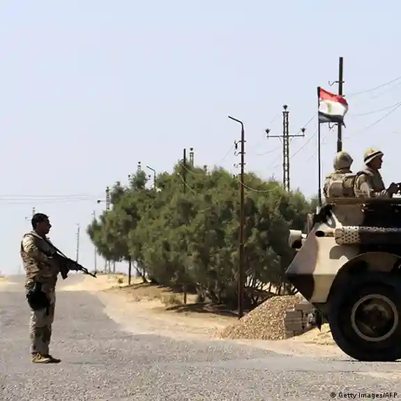 جنود مصريون بجوار مدرعة وعلم مصر عند نقطة على طريق في سيناء؛ صورة أرشيفية.